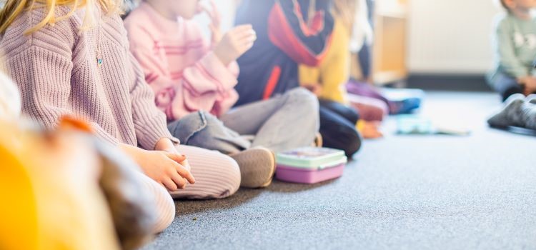 barn som sitter i rad på golvet
