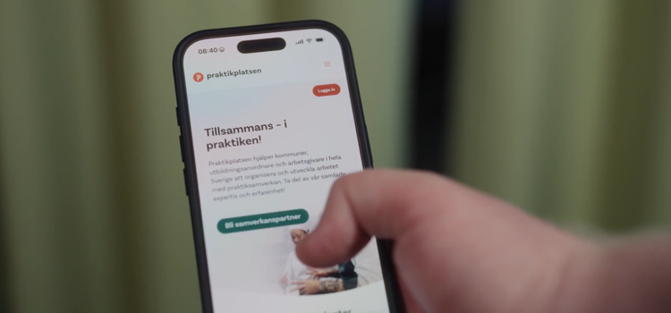 mobiltelefon i hand med praktikplatsen.se på skärmen