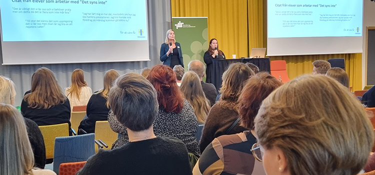 Deltagare på konferens lyssnar på presentatörer