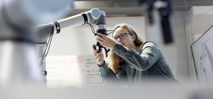 Kvinna vid en industrirobot