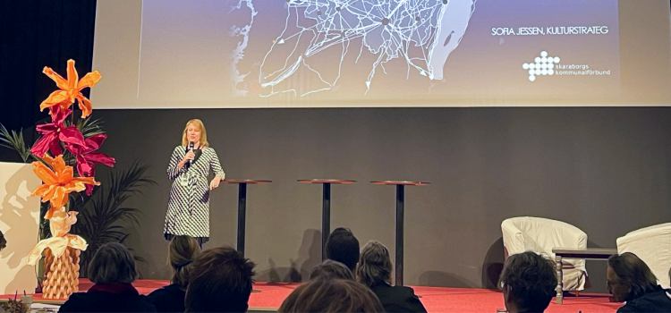 Talare på scen med publik i förgrunden