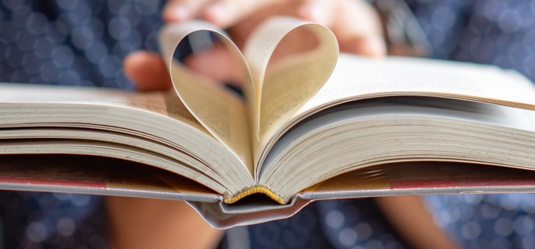 Närbild på uppslagen bok där två sidor bildar ett hjärta